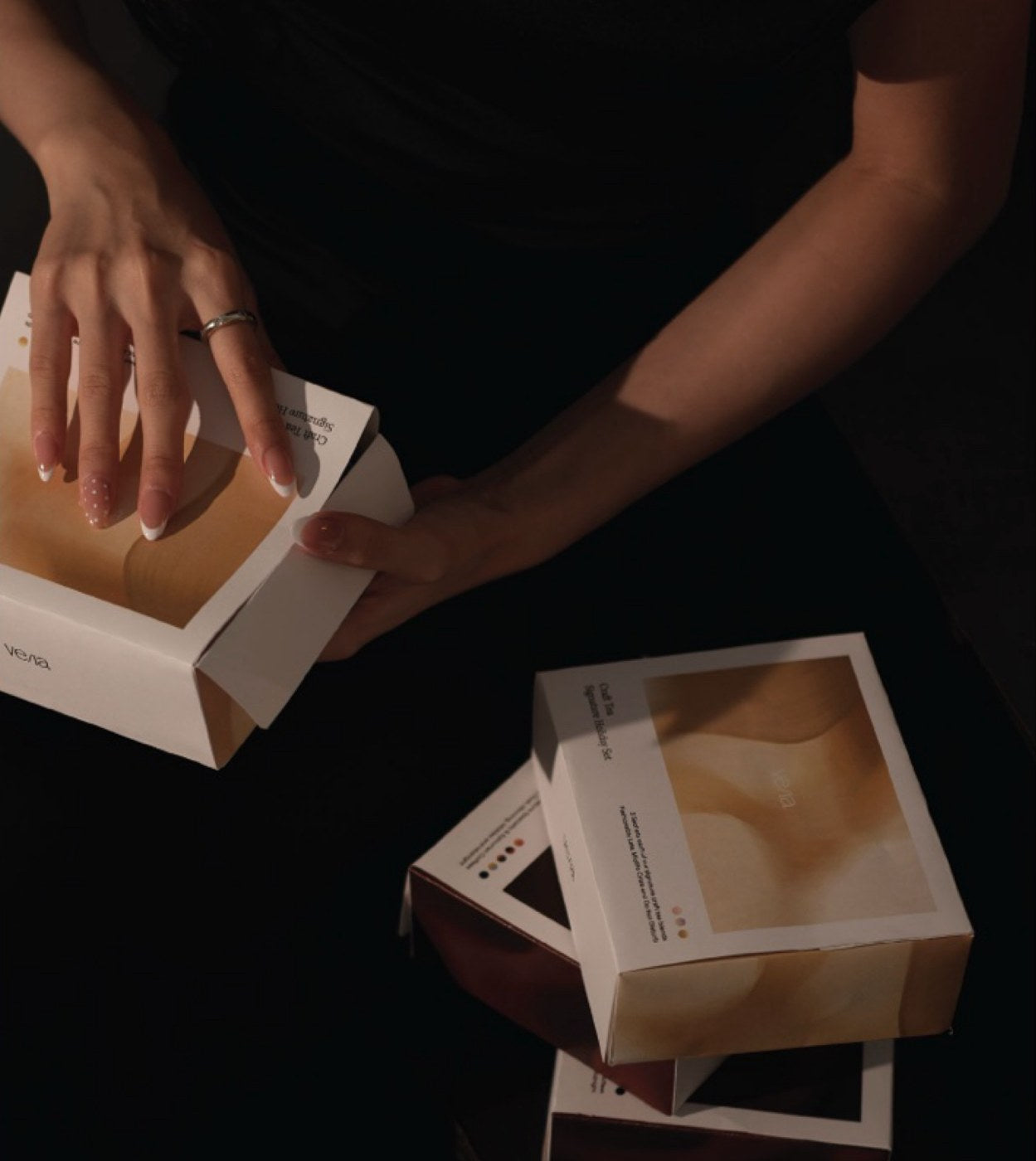 Hands opening a VE/LA gift box